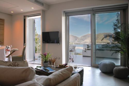 a living room with a couch and a large window at NESOS SUITE by DomuSicily in Mondello