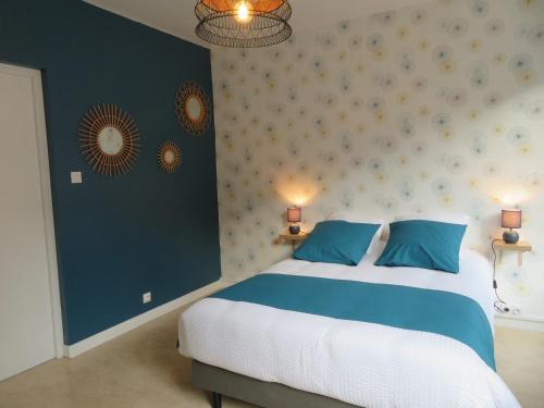 - une chambre avec un grand lit et des oreillers bleus dans l'établissement L'étape Normande, à Fécamp