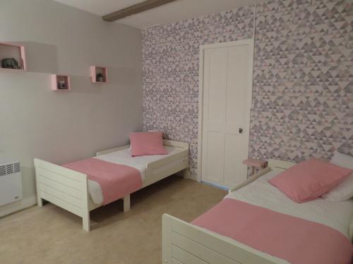 two beds in a room with pink and white at L'étape Normande in Fécamp