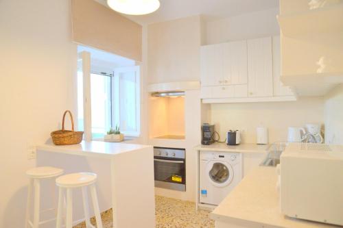 a kitchen with white cabinets and a washer and dryer at Tranquille House in Provatas