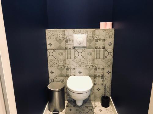 a bathroom with a toilet and a blue wall at Hotel restaurant LA PLACE in Saint-Amand-Montrond