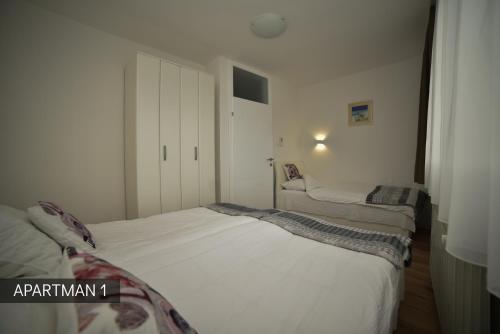 a bedroom with two beds in it with a closet at Apartman Slatki dom 1 in Sarajevo