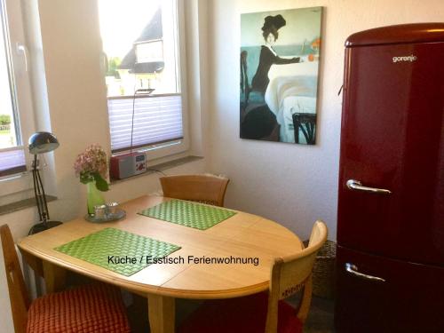 1 dormitorio y cocina con mesa de madera. en Ferienhaus Us lütt Hus und das Zimmer Linde im Haupthaus en Oldenburg