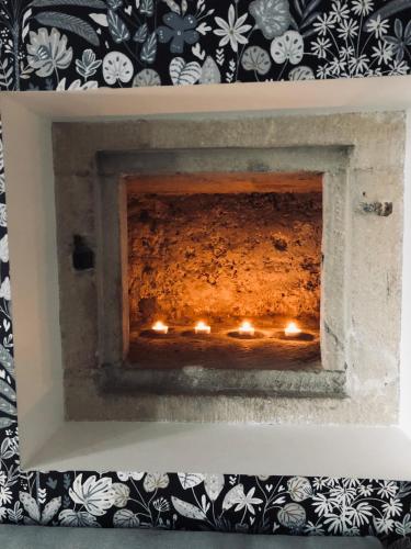 a fireplace with candles in it with a black and white wallpaper at Hotel restaurant LA PLACE in Saint-Amand-Montrond
