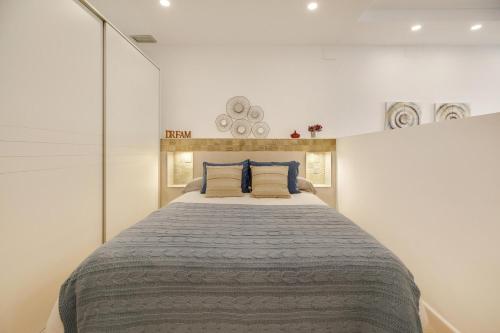 sypialnia z dużym łóżkiem z niebieskimi poduszkami w obiekcie Apartamento Naypa with free parking w Kadyksie