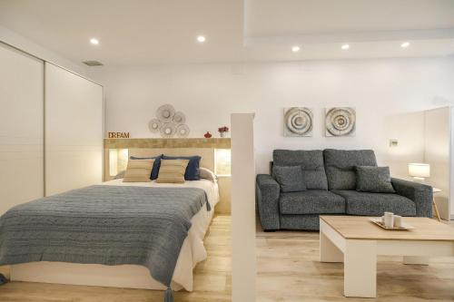 1 dormitorio con cama extragrande y sofá en Apartamento Naypa with free parking, en Cádiz