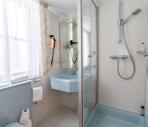 a bathroom with a sink and a shower at Hotel Zum Ochsen in Schonwald im Schwarzwald