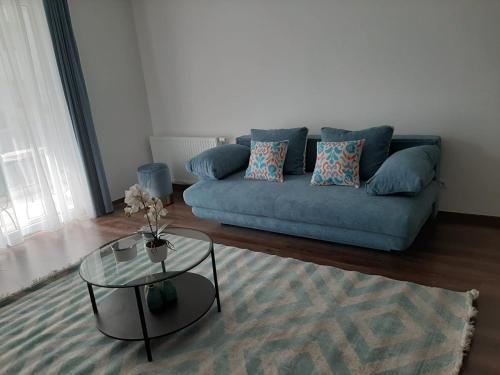 a living room with a blue couch and a glass table at Rozsa55 apartment 2 rooms in Budapest