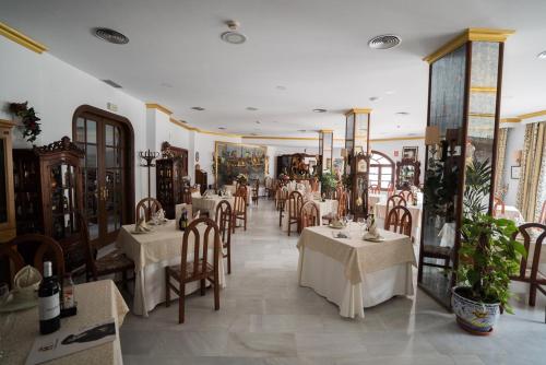 a restaurant with tables and chairs in a room at Hotel Pozo del Duque in Zahara de los Atunes