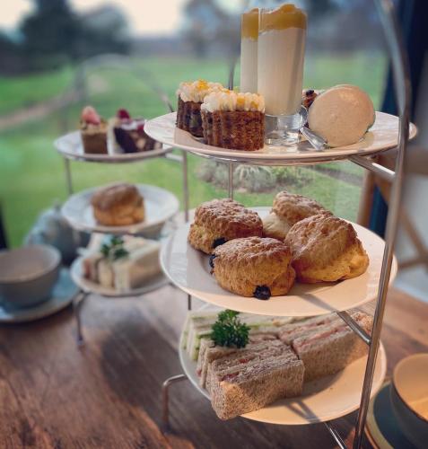 a display of different types of pastries on three tiers at Cottesmore Hotel Golf & Country Club in Crawley