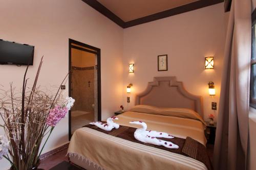 a bedroom with a bed with two towels on it at Riad Al Madina in Essaouira