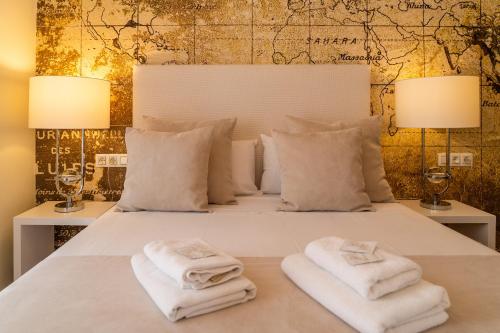 バレンシアにあるPuerto Rico Apartments Ruzafaのベッド1台(タオル、ランプ2つ付)