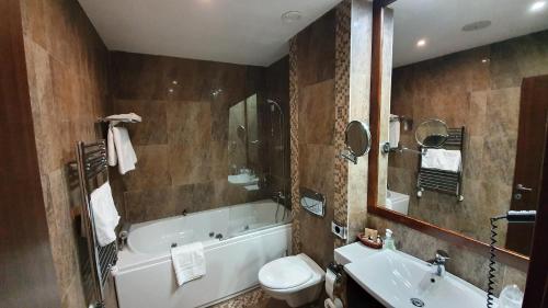 a bathroom with a tub and a toilet and a sink at Apartament 2711 , proprietate privata in Aparthotel Alpin in Poiana Brasov