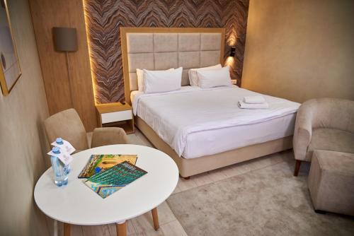 Habitación de hotel con cama, mesa y sillas en EDEM Hotel en Türkistan
