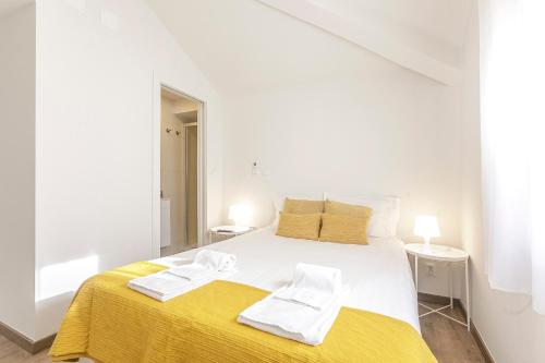 a white bedroom with a large bed with two towels on it at LovelyStay - 1st A Mirante in Porto