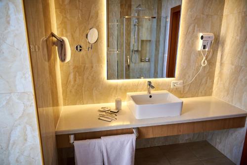 La salle de bains est pourvue d'un lavabo et d'un miroir. dans l'établissement EDEM Hotel, à Türkistan