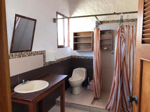a bathroom with a sink and a toilet at tierrabrava-hospedaje in Cojimíes