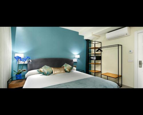 a bedroom with a bed with a blue wall at Pensión Plaza Nueva in Bilbao