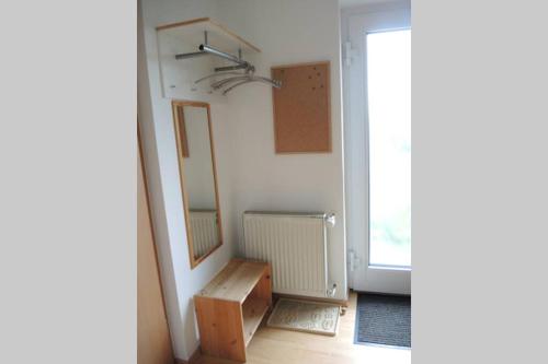 Cette chambre comprend un miroir, une table et une fenêtre. dans l'établissement Apartement am Kirschbaum, à Mommenheim