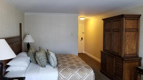 a bedroom with a bed and a wooden cabinet at Chelsea Inn in San Francisco