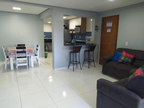 a living room and kitchen with a couch and a table at Paraiso do Sul Maragogi in Maragogi