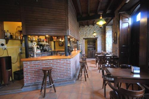 restauracja ze stołami i krzesłami oraz bar w obiekcie Albergue La Posada Cangas de Onis w mieście Cangas de Onís