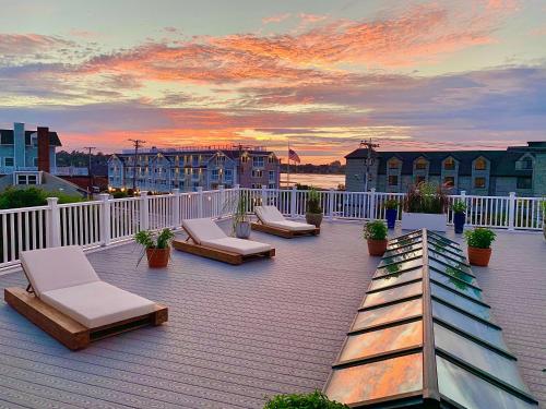 ミドルタウンにあるAtlantic Beach Hotel Newportのラウンジチェアと夕日を望む屋上デッキ
