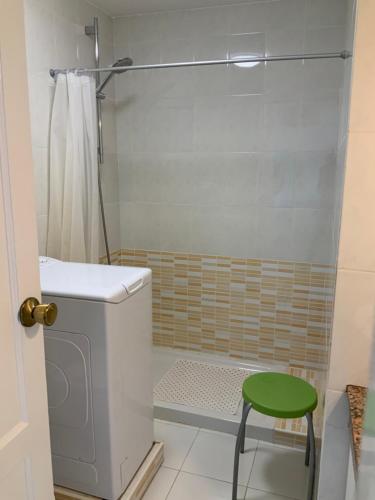 a bathroom with a shower and a green stool at El bañadero in El Cotillo