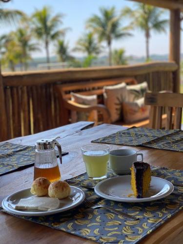 a table with two plates of food and drinks on it at Pousada Lago Azul in Delfinópolis