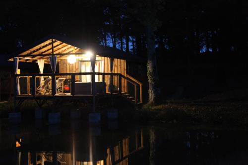 ein beleuchtetes Haus auf einem Dock in der Nacht in der Unterkunft Whaka Lodge in Seissan