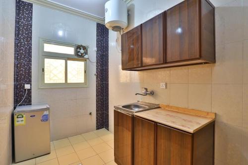 eine kleine Küche mit Spüle und Fenster in der Unterkunft البيت الأخضر - شقق مخدومة Green House in Abha