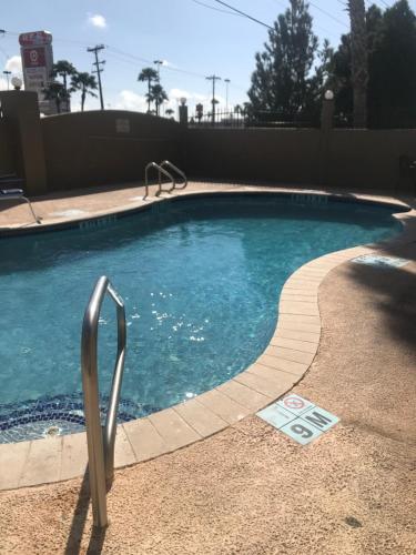 a swimming pool with a metal railing next to it at Shary Inn and Suites in Mission