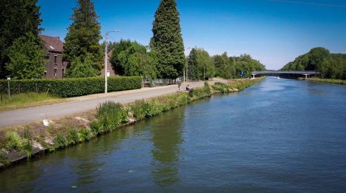 a river next to a road and a street at Villa van Brienen - Studio in Dilsen-Stokkem