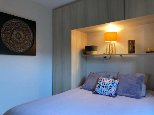 een slaapkamer met een bed met een kussen erop bij Résidence Coté Village in Valbonne