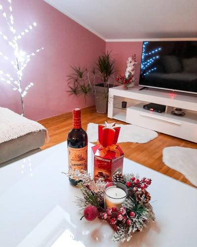 a living room with a bottle of wine and christmas decorations at Apartman Japanski vrt, Centar in Vrnjačka Banja