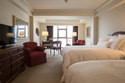 a hotel room with two beds and a television at Swissotel Lima in Lima