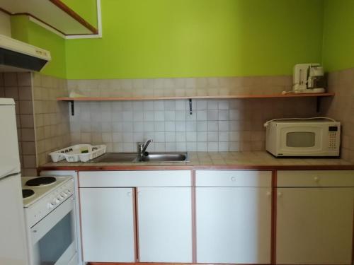 a kitchen with a sink and a microwave at Hotel Dry Les Courtis in Robertville