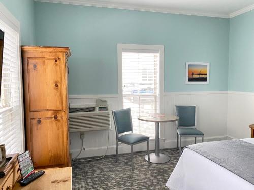 a bedroom with a bed and a table and chairs at Harbor House Inn in Grand Haven
