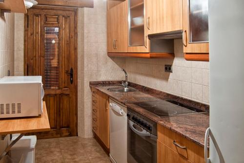 a kitchen with a sink and a stove top oven at Casa Rural Campoamor in Riópar