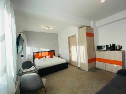 um quarto de hotel com uma cama e um micro-ondas em Orange House Constanta em Constança
