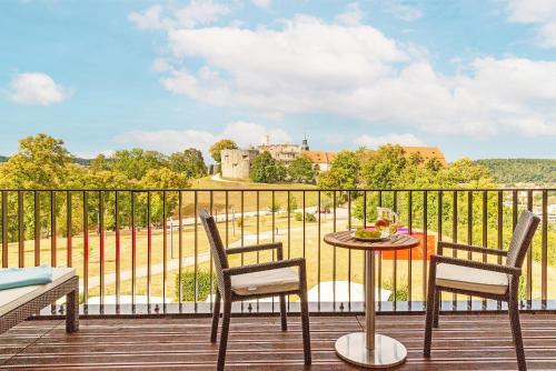 a balcony with a table and chairs and a castle at Schlosshotel Hellenstein in Heidenheim