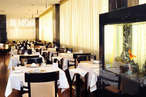 a restaurant with white tables and chairs and a fish tank at Radisson Blu Hotel Lisbon in Lisbon