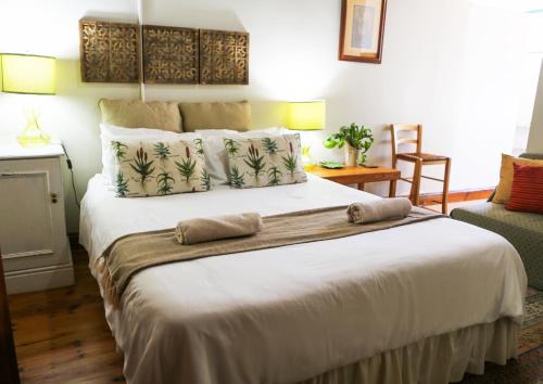a bedroom with a large white bed with pillows at Mr Pell's House Self-Catering Accommodation in Jeffreys Bay