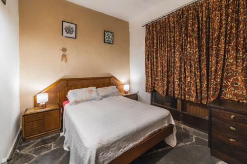 Schlafzimmer mit einem Bett und einem Fenster mit Vorhängen in der Unterkunft 41 Hostel in Punta del Este