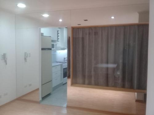 eine Küche mit weißen Schränken und einer Glasschiebetür in der Unterkunft Centrico 05 in General Roca