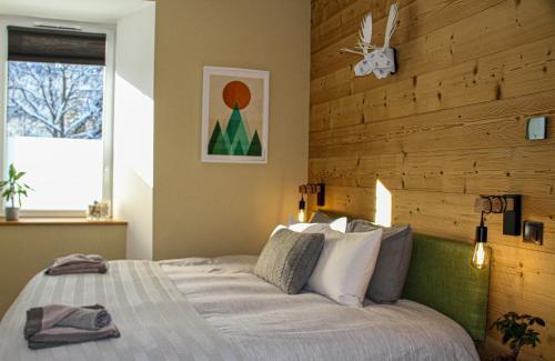 1 dormitorio con 1 cama con pared de madera en Apartment Maya, La Praz, Chamonix Mont Blanc en Chamonix-Mont-Blanc