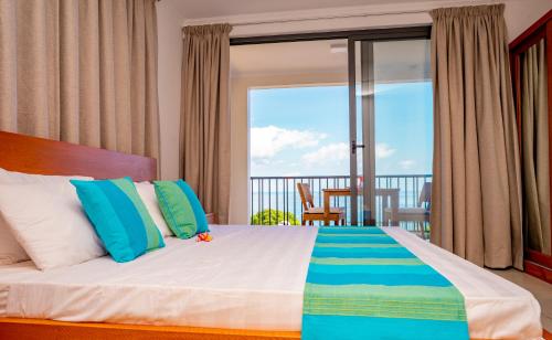 a bedroom with a bed with a view of a balcony at Kolibri Holiday Apartments in Victoria