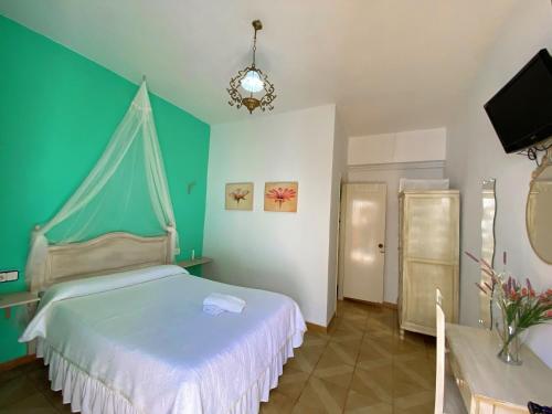 a bedroom with a bed and a green wall at Pensión Cristina in El Rocío