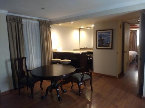 a room with a table and chairs and a bedroom at Rose Hotel in Monterrey