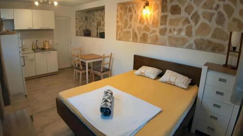 Zimmer mit einem Bett und einer Küche mit einem Tisch in der Unterkunft Island Stone House in Ždrelac